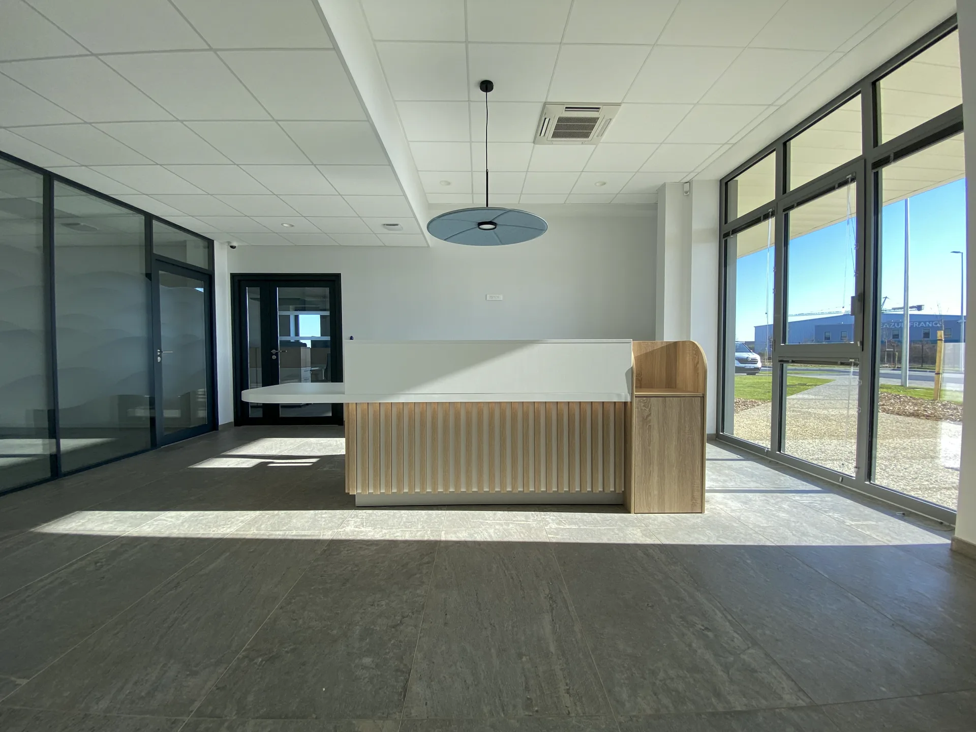 Accueil de bureaux lumineux avec comptoir en bois à tasseaux, aménagement LIV Intérieur