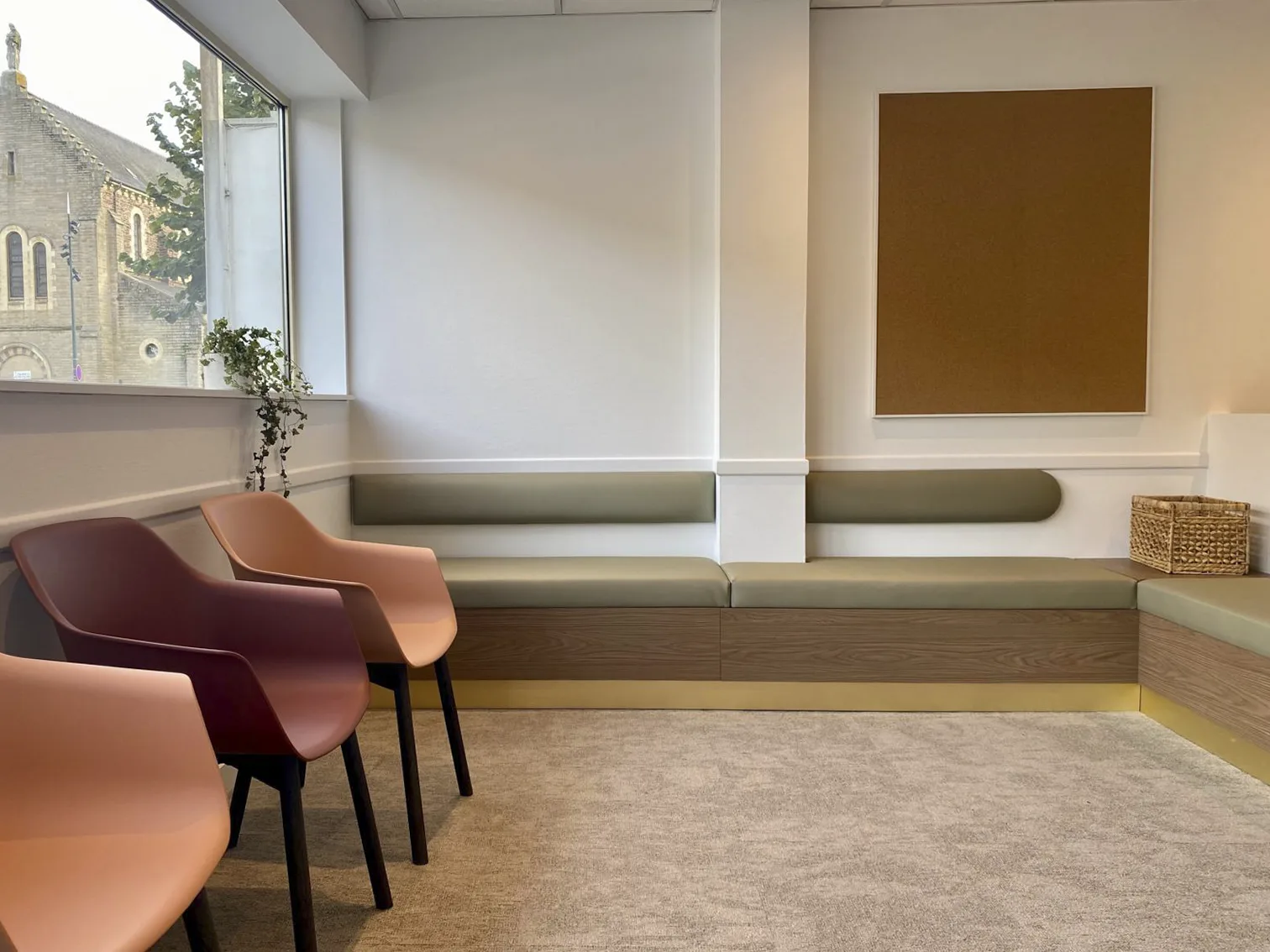 Salle d'attente avec banquette kaki sur-mesure et fauteuils corail, aménagement LIV Intérieur
